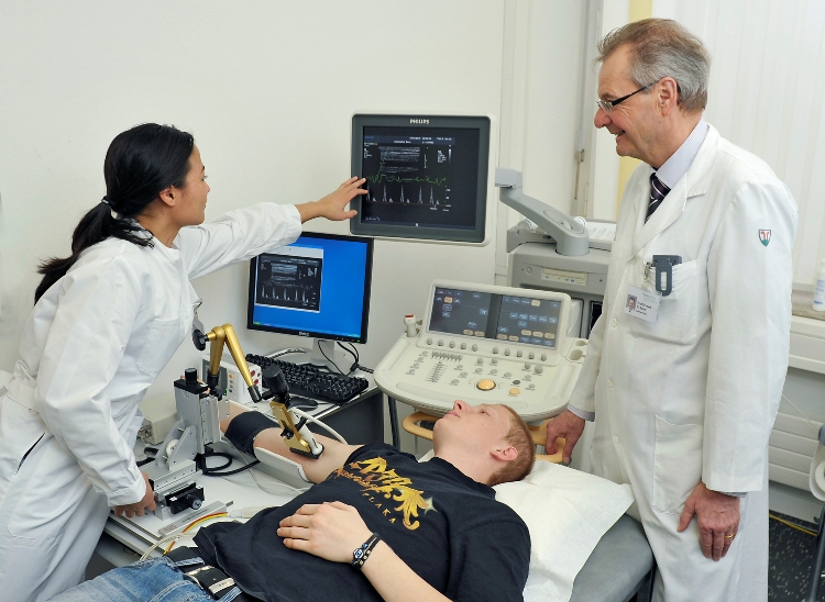 Prof. Hugo Saner (rechts) berwacht im Inselspital Bern die Ultraschallmessung am Oberarm des Patienten. Damit werden die Auswirkungen von Transfettsuren aus Kuhmilch oder Margarine auf die Blutgefsse untersucht. (Foto: Inselspital Bern)